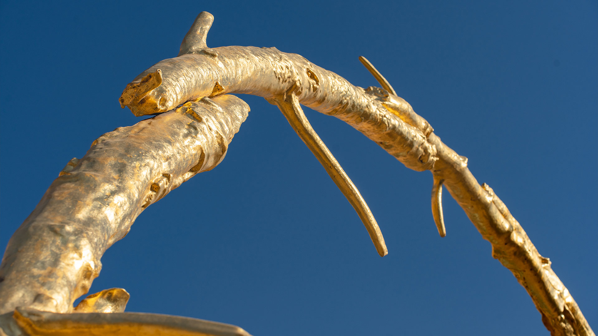 A large, bright yellow circular sculpture by Ugo Rondinone, titled the sun, installed in an open public space in Riyadh.