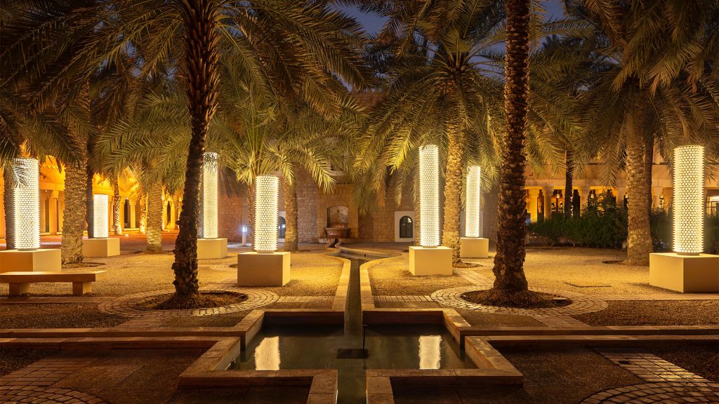 Abdulrahman Taha’s Midwan – The Palm Forest (2024), a light installation featuring seven palm trunk–like pillars covered in thousands of illuminated spinning tops, inviting visitors to walk through a glowing forest of light in Riyadh.