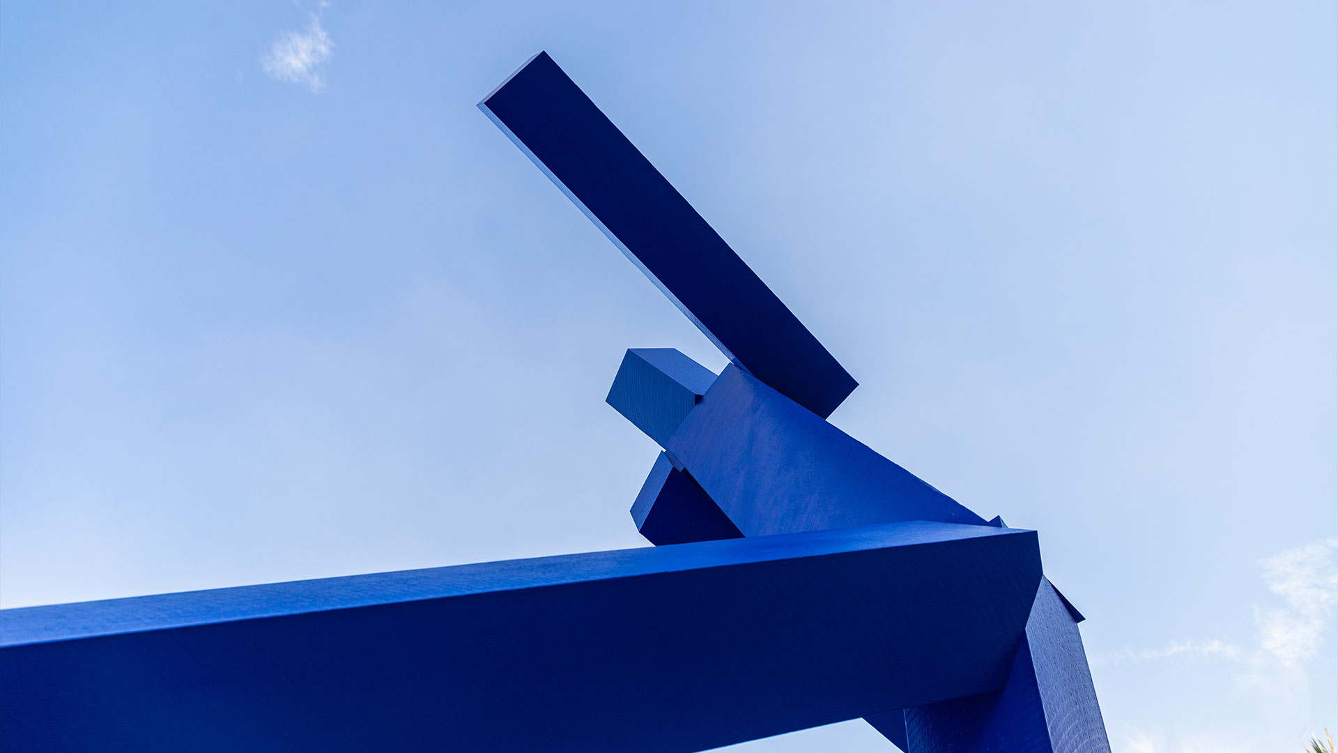 An abstract bronze sculpture by Joel Shapiro, titled Untitled, featuring angular forms that suggest a human figure in motion, installed outdoors in Riyadh.