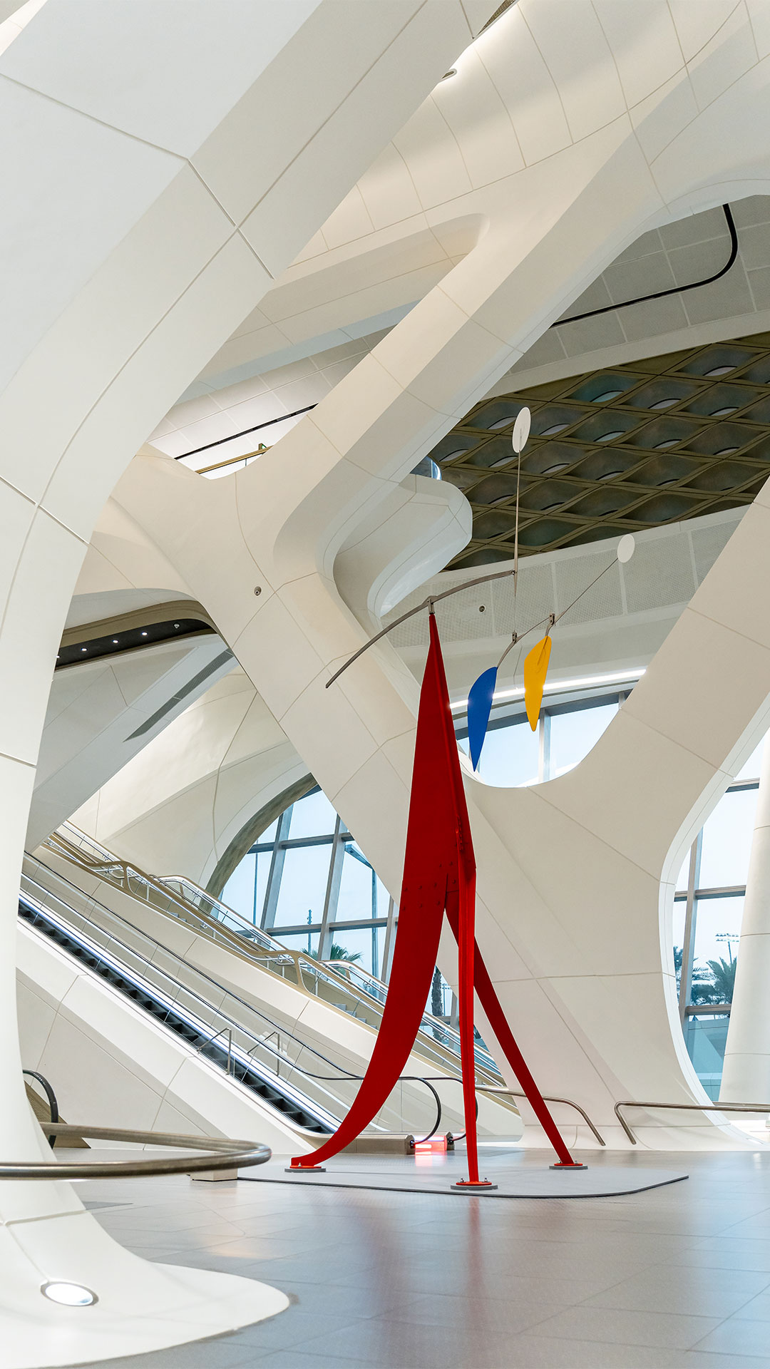 Alexander Calder’s sculpture Janey Waney, a tall red painted steel stabile with suspended blue and yellow mobile elements, installed in the KAFD Metro Station in Riyadh