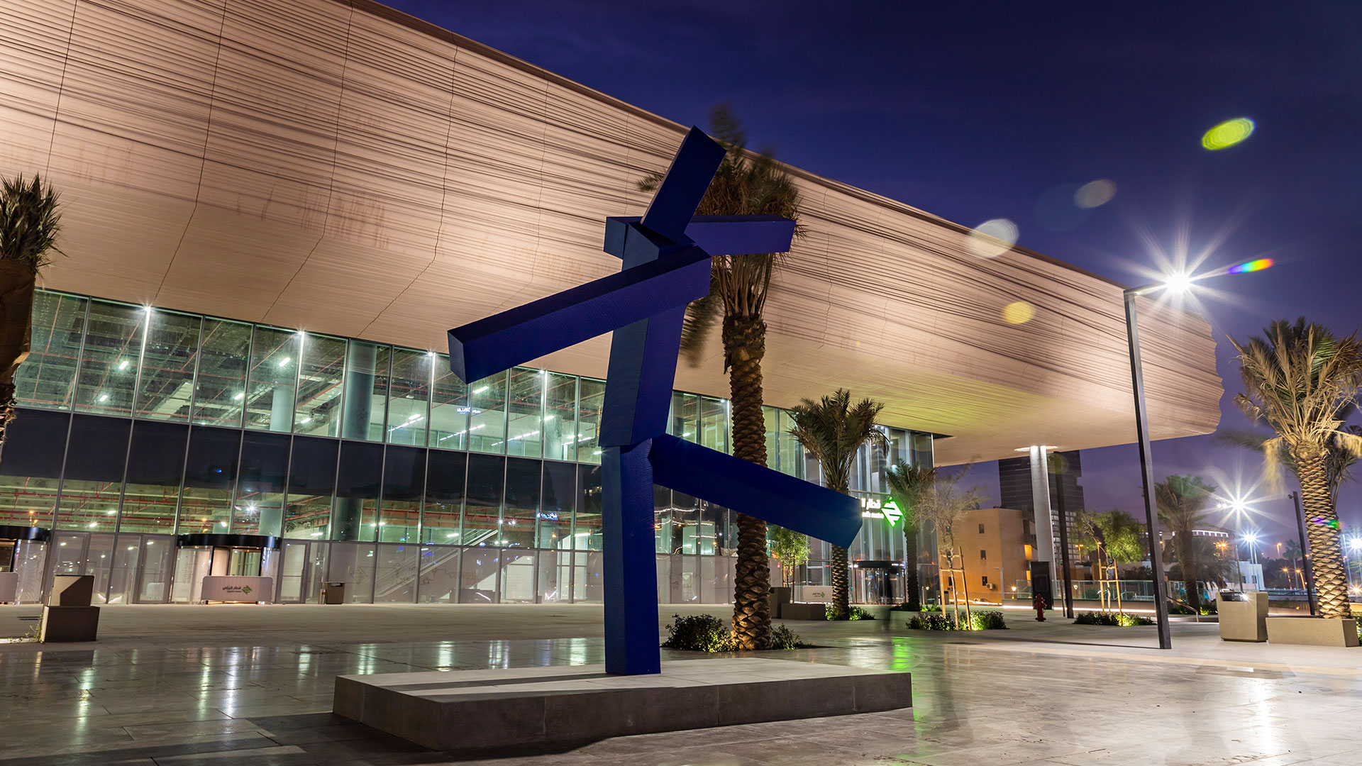 An abstract bronze sculpture by Joel Shapiro, titled Untitled, featuring angular forms that suggest a human figure in motion, installed outdoors in Riyadh.