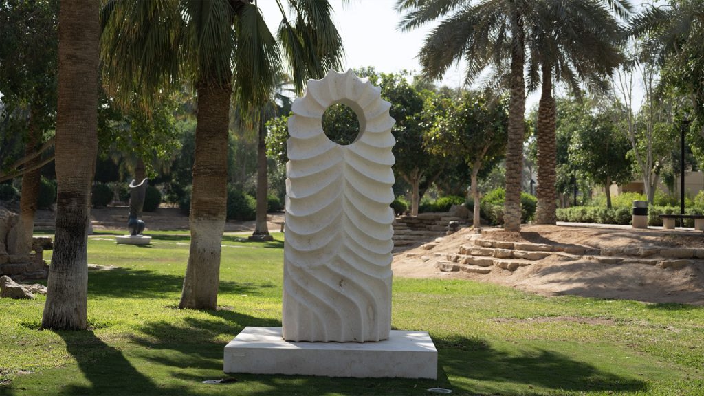 Haider Alawi Al-Alawi’s Desert Lines (2021), a carved stone sculpture with flowing, wave-like grooves, installed at King Abdulaziz Historical Center (KAHC) in Riyadh, inspired by patterns formed by wind and water in nature.