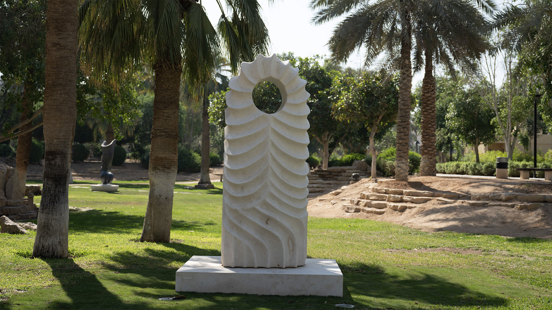 Haider Alawi Al-Alawi’s Desert Lines (2021), a carved stone sculpture with flowing, wave-like grooves, installed at King Abdulaziz Historical Center (KAHC) in Riyadh, inspired by patterns formed by wind and water in nature.