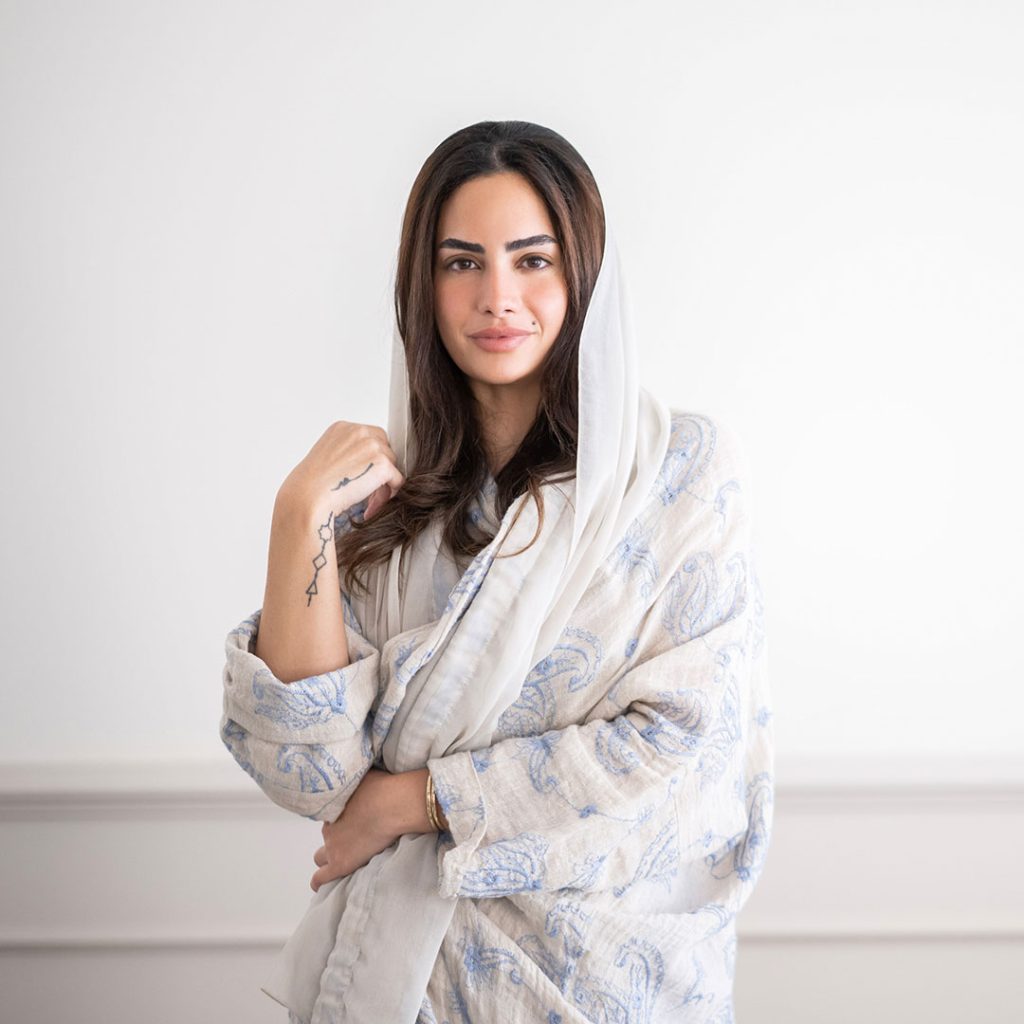 Portrait of Jumana Ghouth, Saudi curator and cultural strategist, standing in a contemporary exhibition space. Known for her work at ATHR and the Ministry of Culture, she is a key figure in Saudi Arabia’s contemporary art movement.