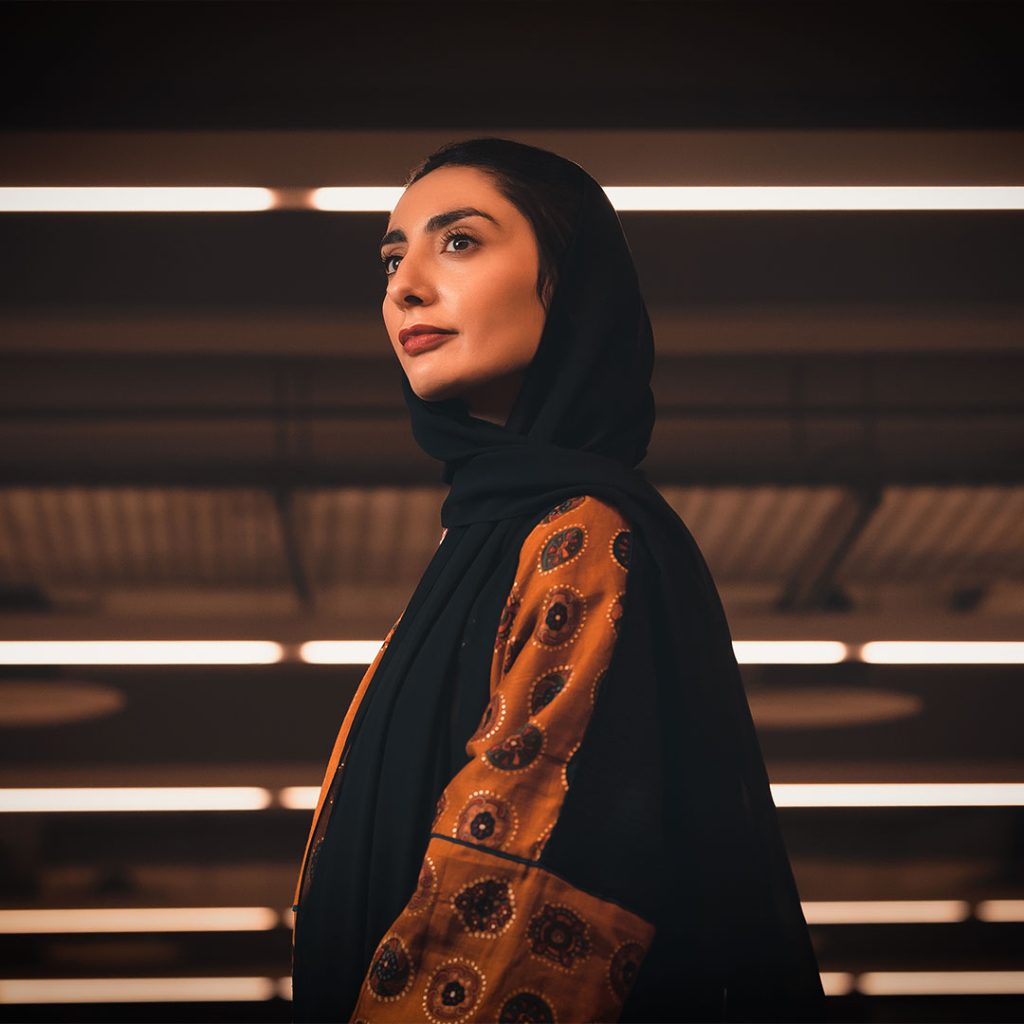 Portrait of Maya Al Athel, Saudi curator and cultural entrepreneur, standing confidently in a contemporary setting. She is known for her role in shaping major cultural initiatives in Saudi Arabia, including Noor Riyadh and Almanac Collective.